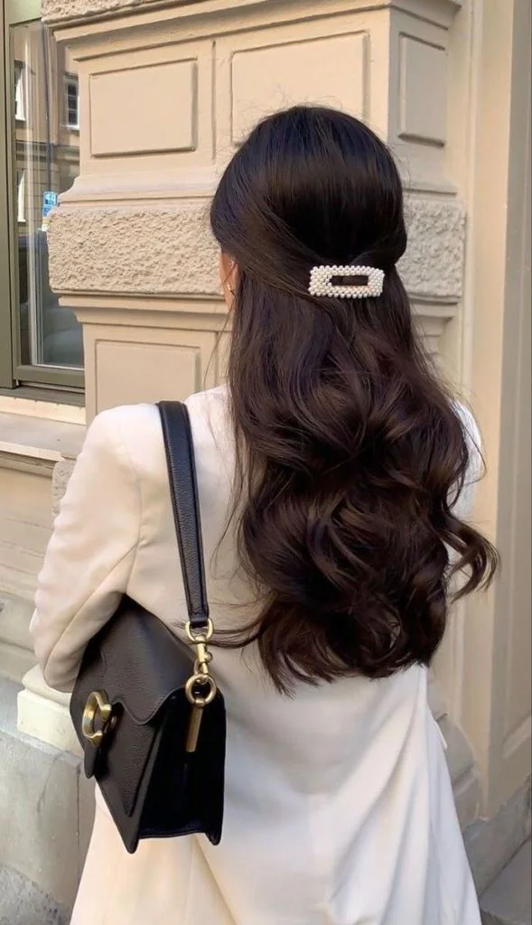 chest straight chestnut ponytail shown as a simple wedding guest hair idea