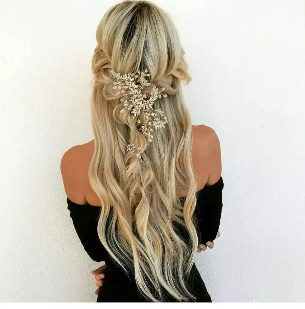 chest wavy brunette ponytail shown as a simple wedding guest hair idea