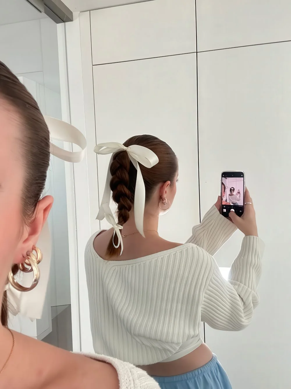 Photo showing braid with bows, with the hairstyle clearly visible.