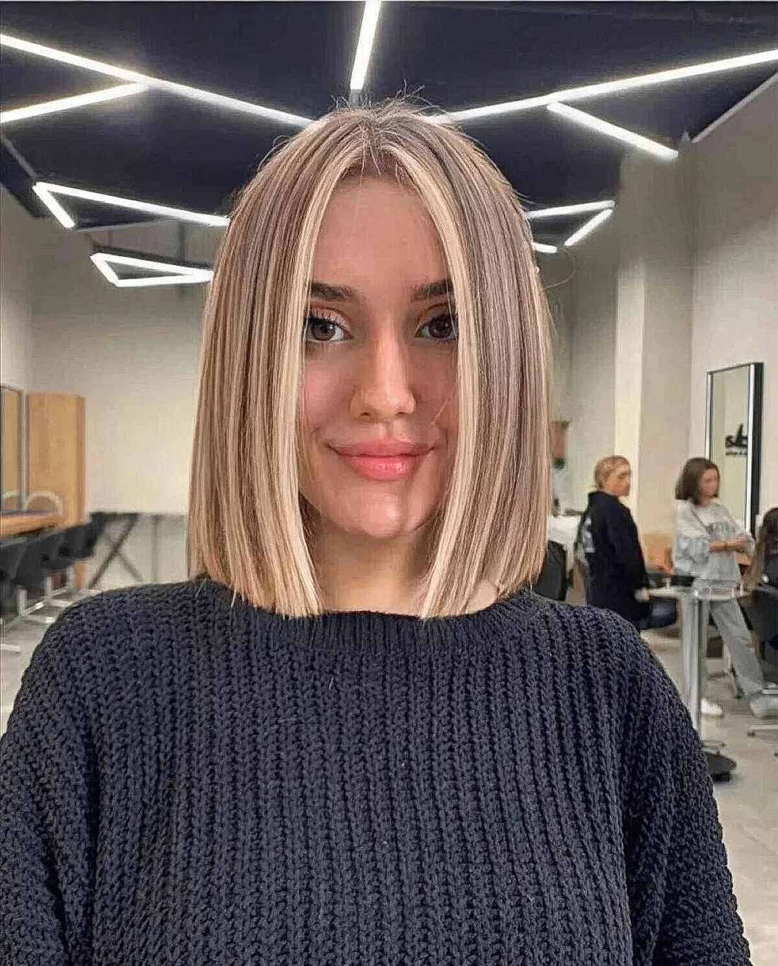 Shoulder-length blunt slob with slight blonde balayage and longer layers on top.