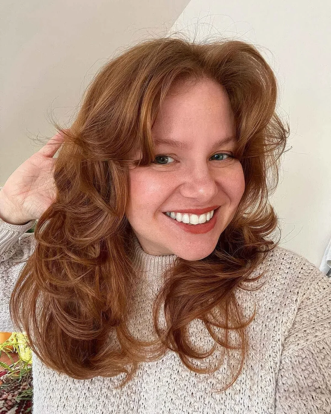 Medium-length cinnamon haircut with curls and soft curtain bangs.