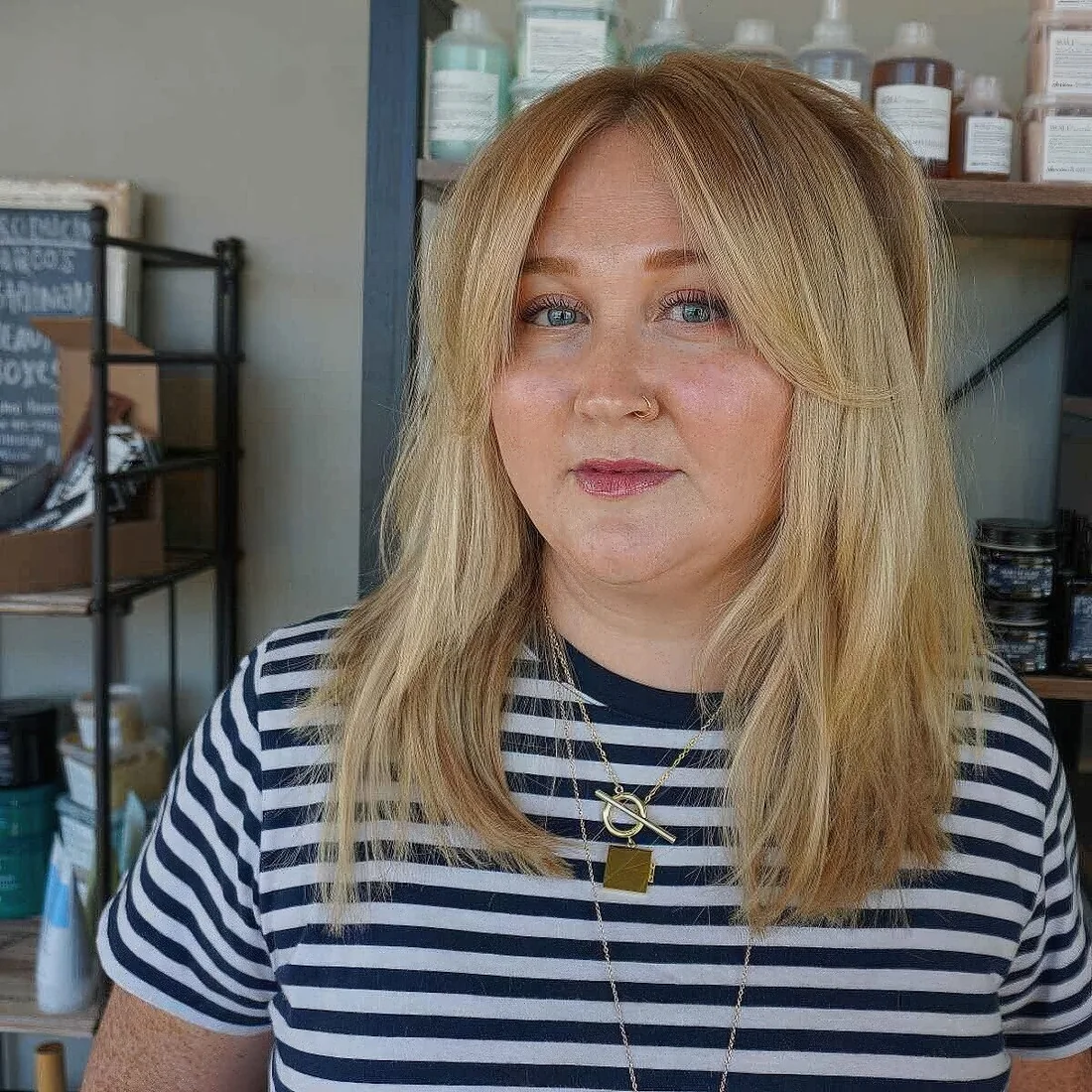 Mid length blonde hair with curtain bangs that accent the face in a lovely and cool way.