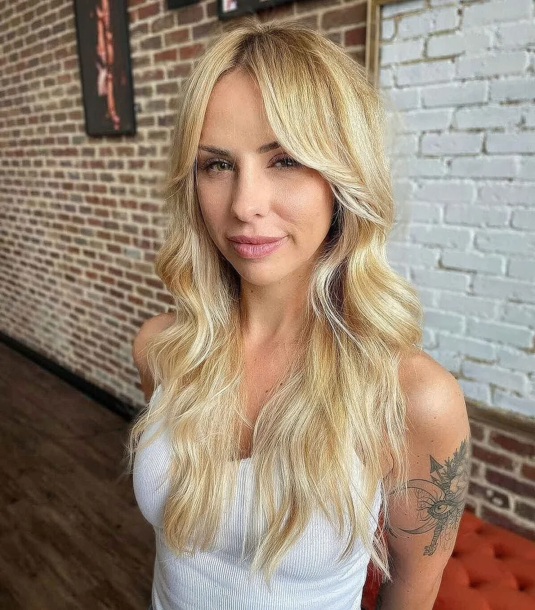 Long blonde hair with shaggy ends and center-parted bangs that are great for framing the face.