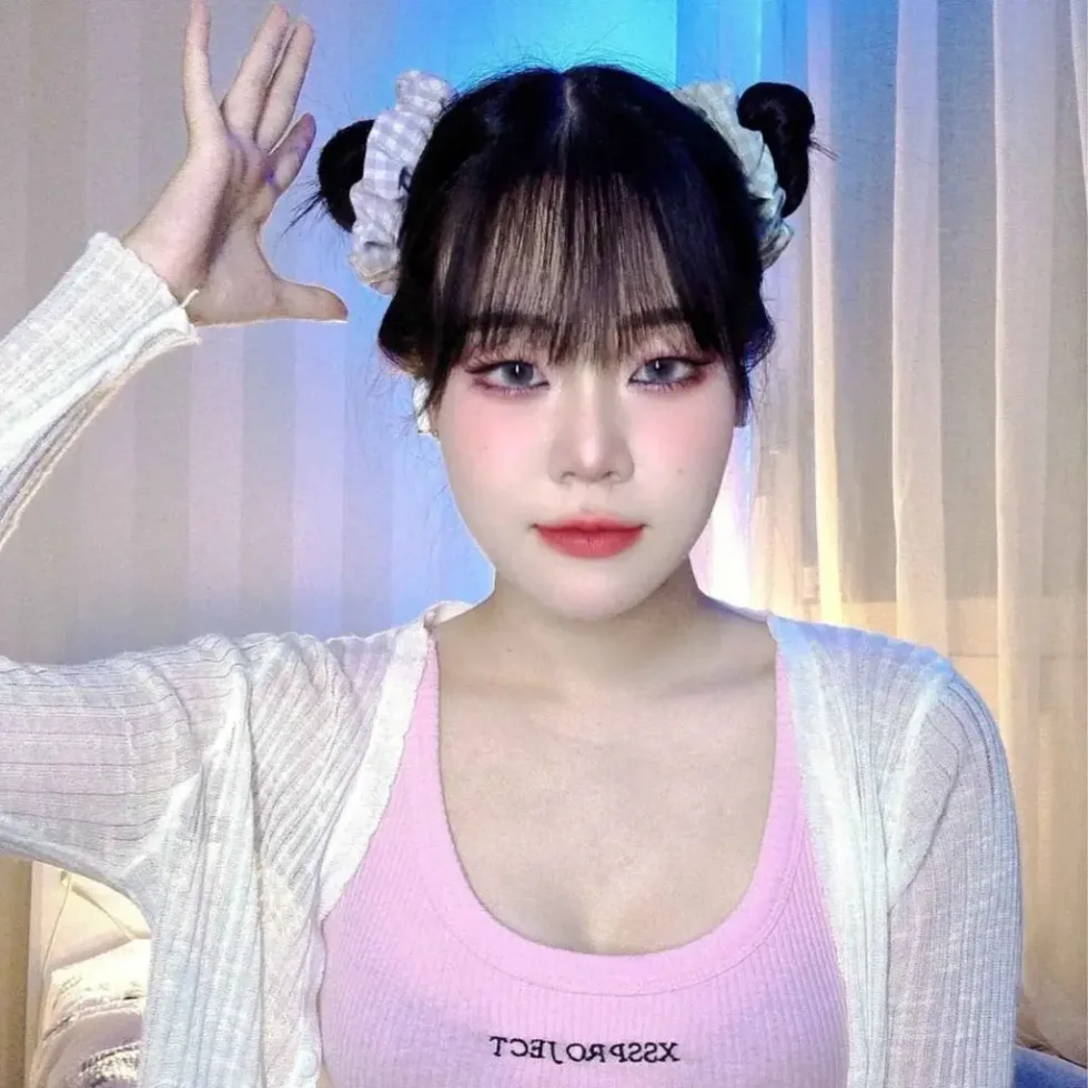 shoulder straight black bun with wispy fringe shown as a space buns idea