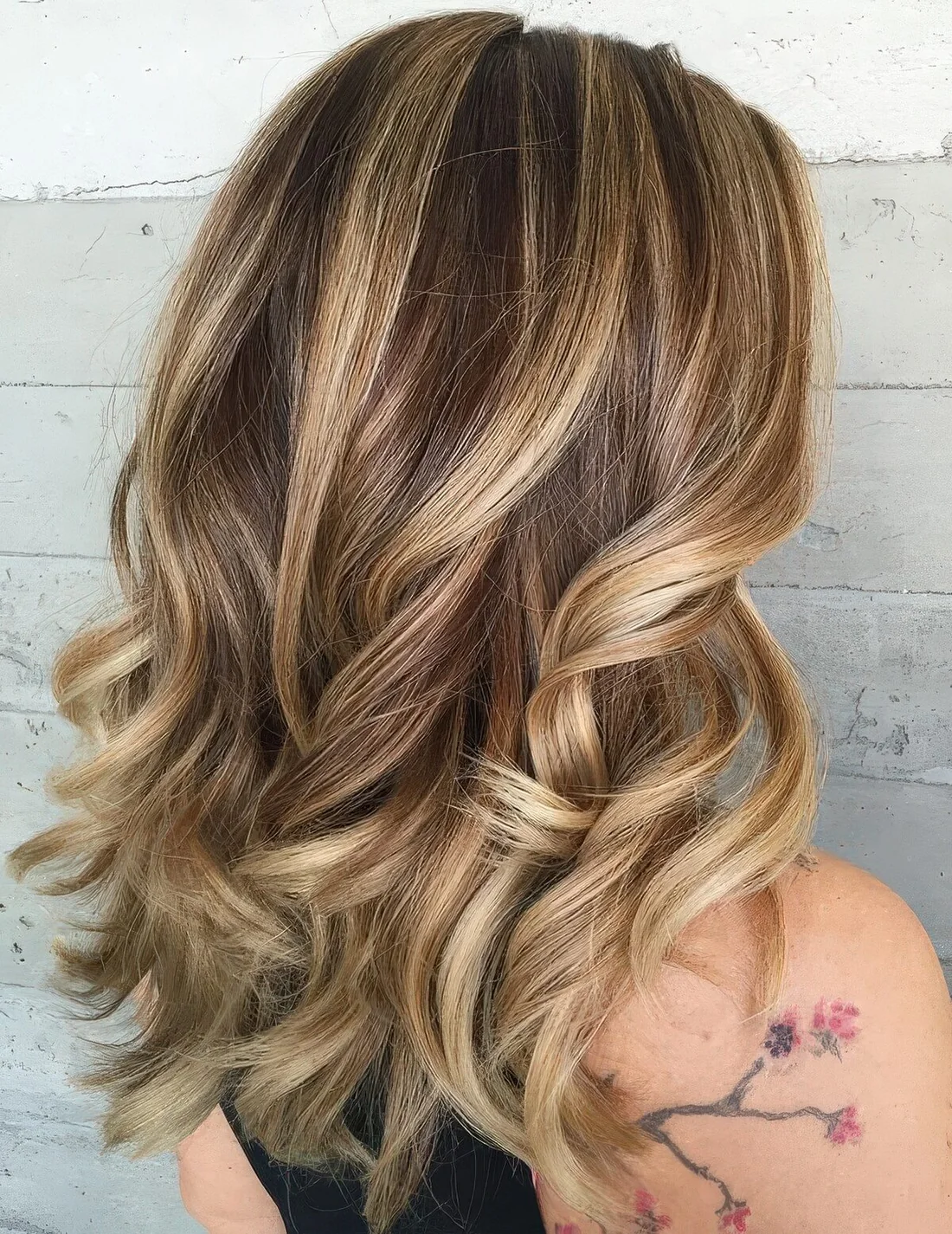 Brunette hair with blended blonde highlights and waves.