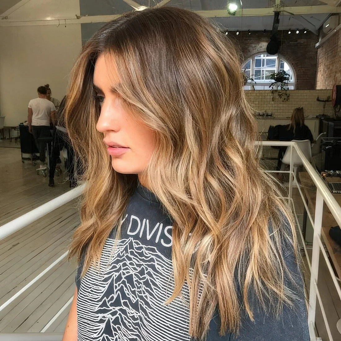Brown hair with a pop of honey blonde placed to frame the face and with an angled scheme.