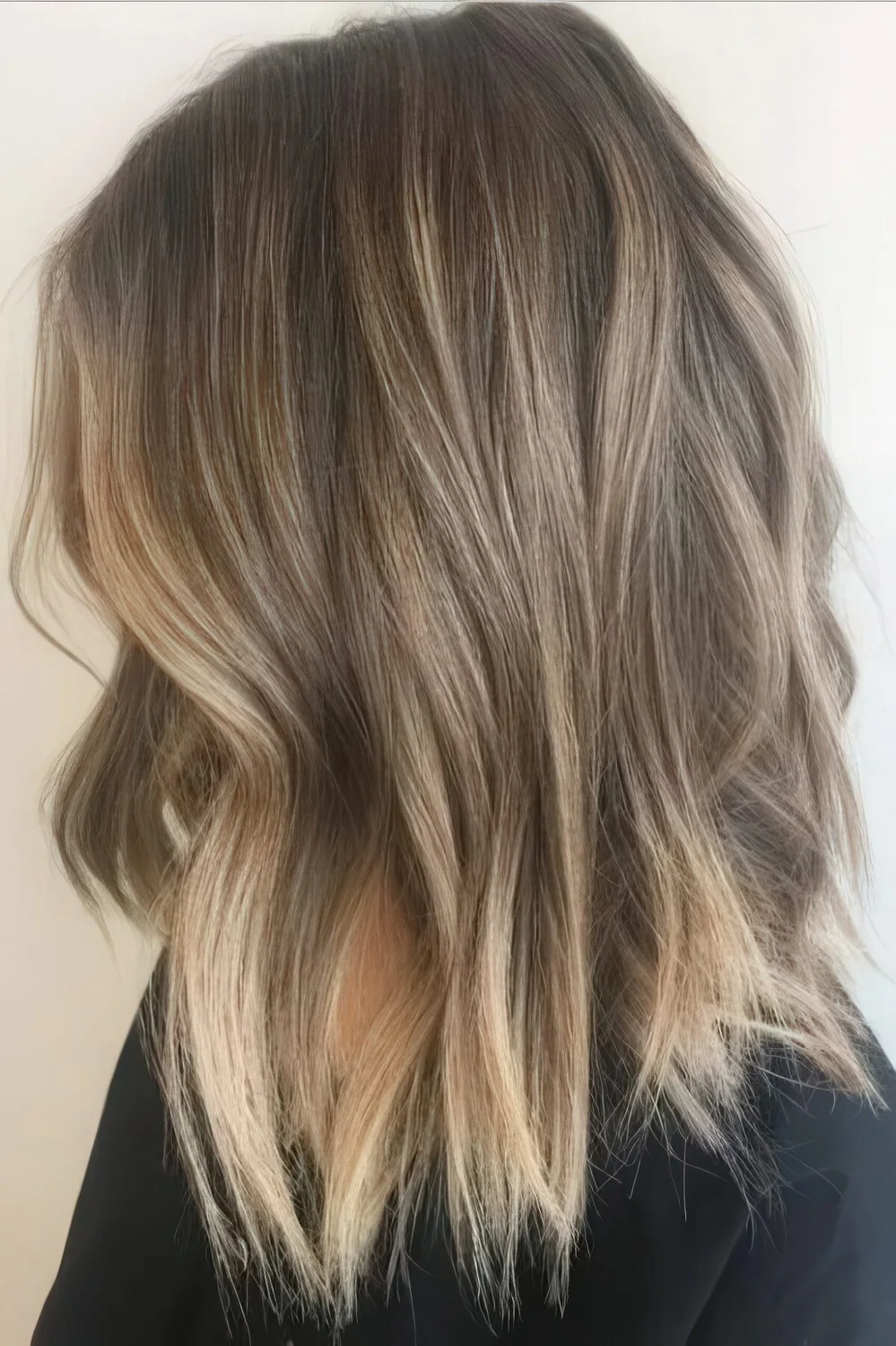Cold light brunette hair with blended sunkissed balayage and beachy waves.