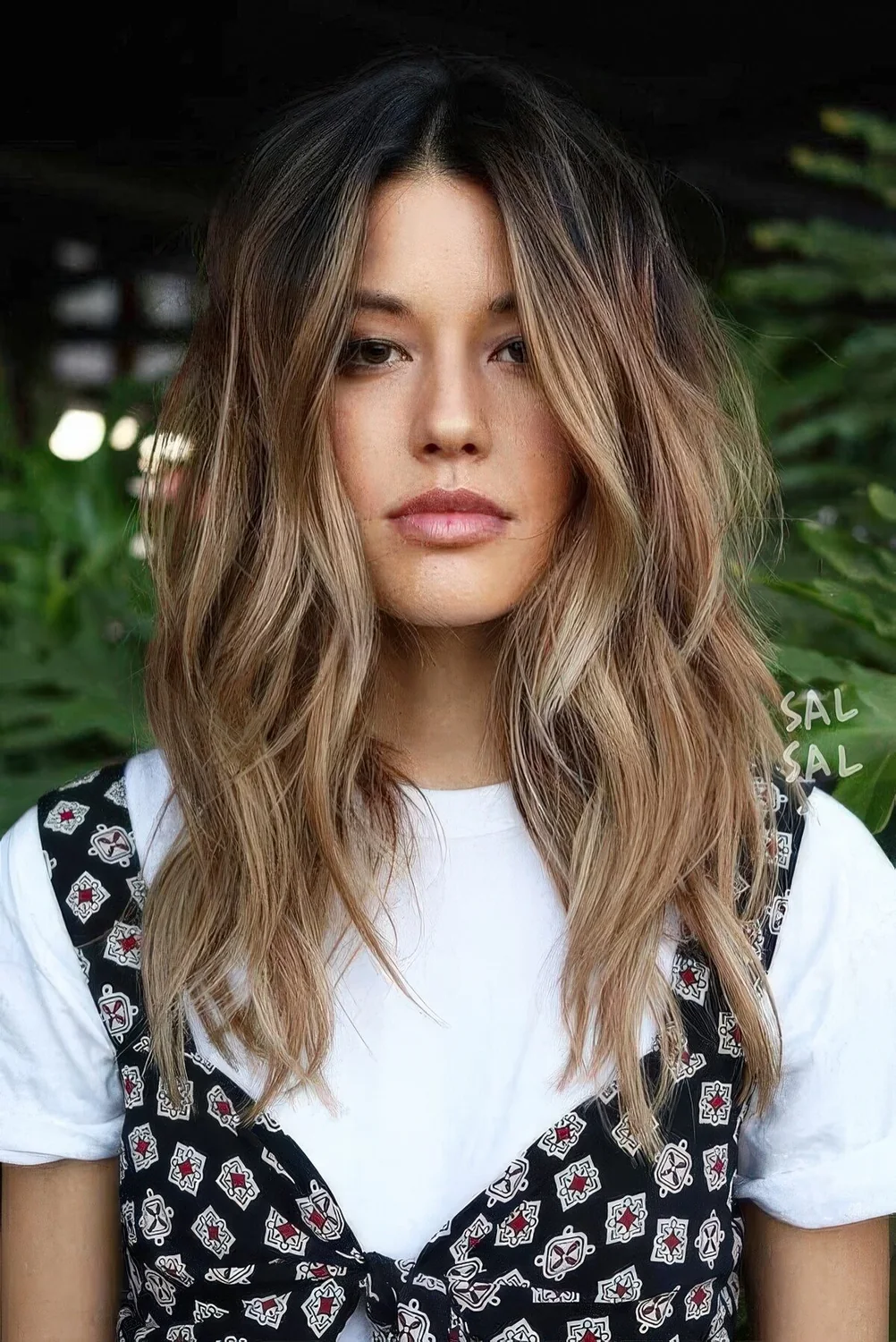 Dark brunette hair with beautiful and messy waves and sunkissed balayage.