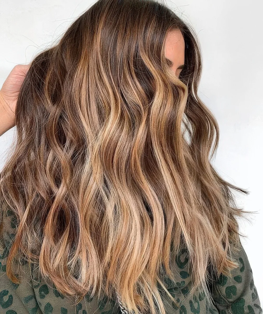 Long wavy brunette hair with sunkissed balayage.