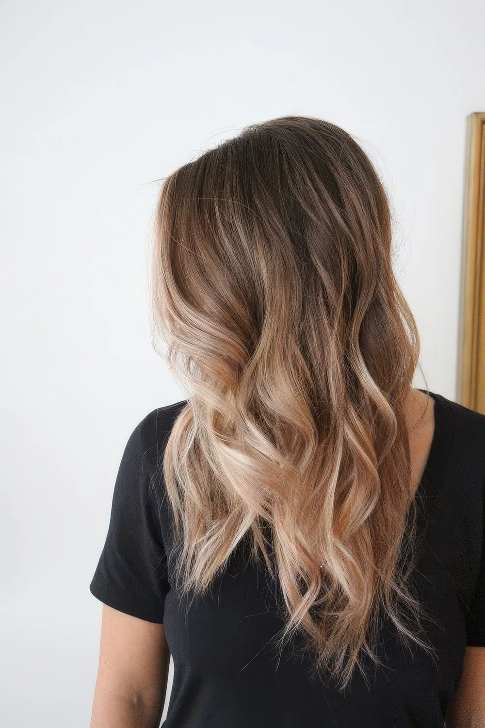 Long sunkissed blonde with a darker root and waves.