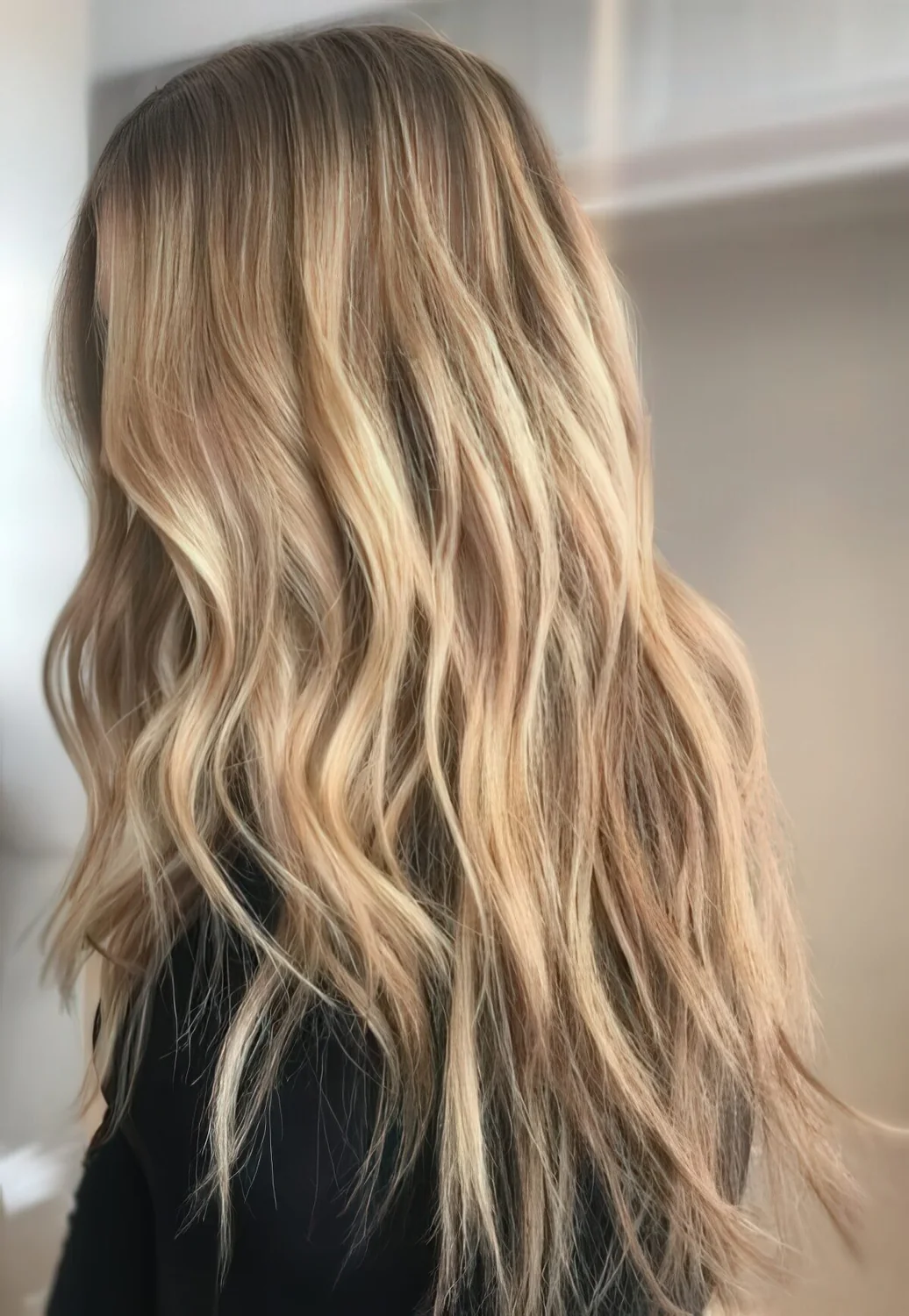 Very natural and delicate long sunkissed hair with waves and a darker root.