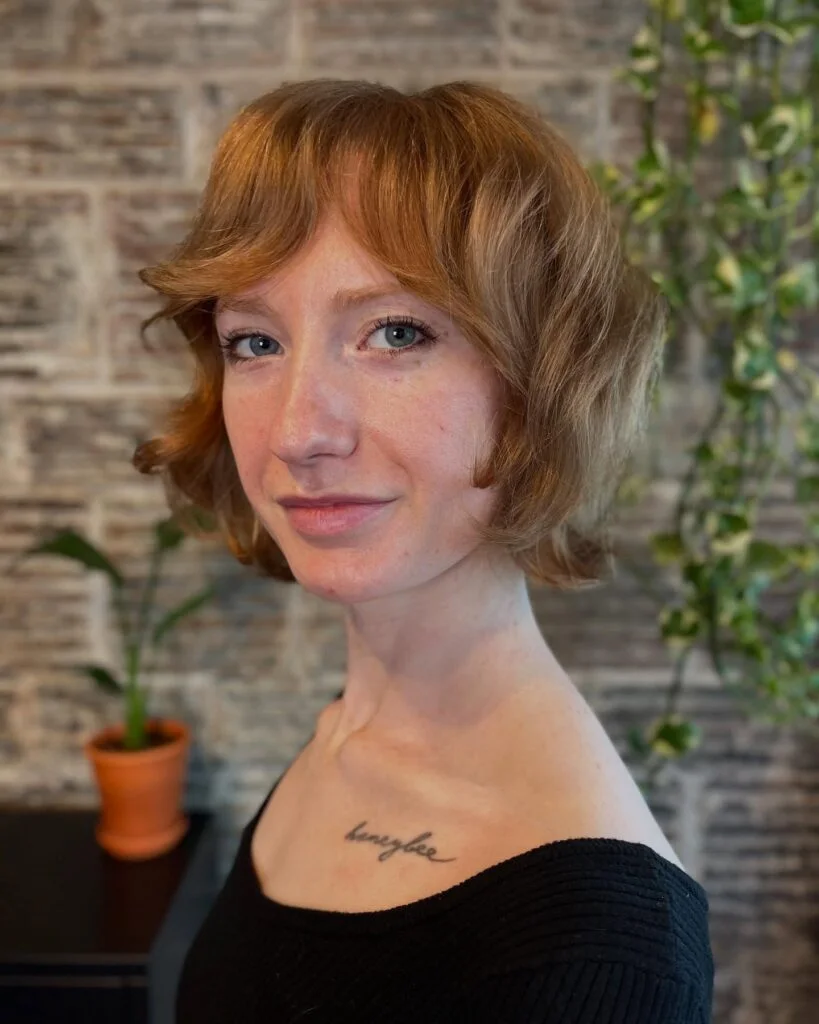 jaw wavy copper bob with curtain fringe shown as a textured bob for thin hair idea
