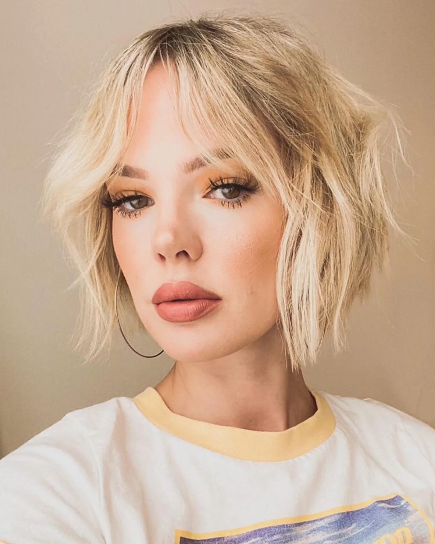 chin wavy blonde bob with wispy fringe shown as a textured bob for thin hair idea