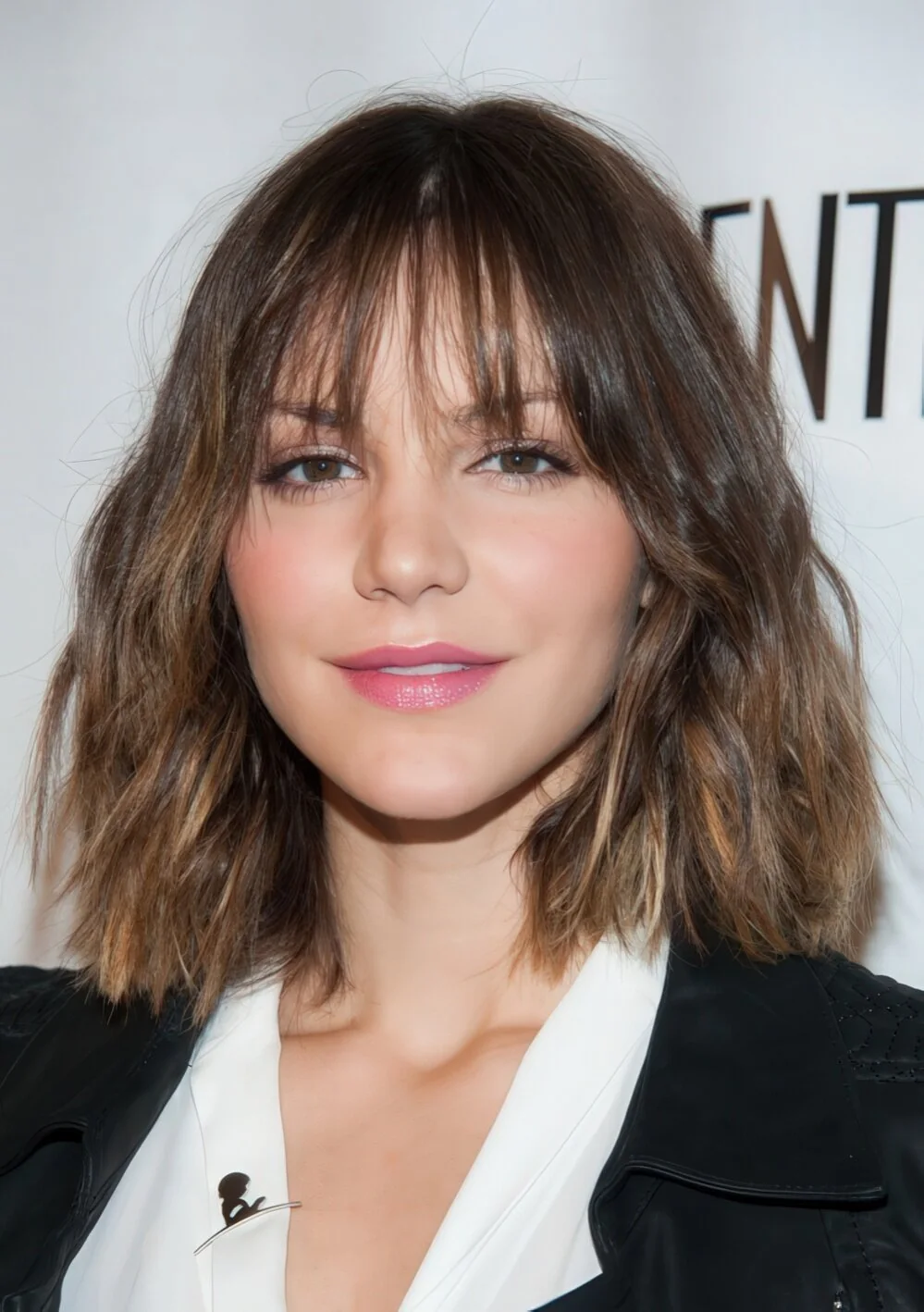 Tousled brunette wavy lob with wispy bangs.