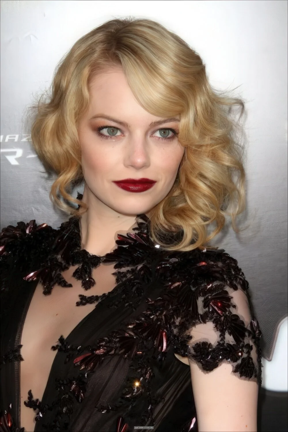 Blonde curled bob with a deep side part.