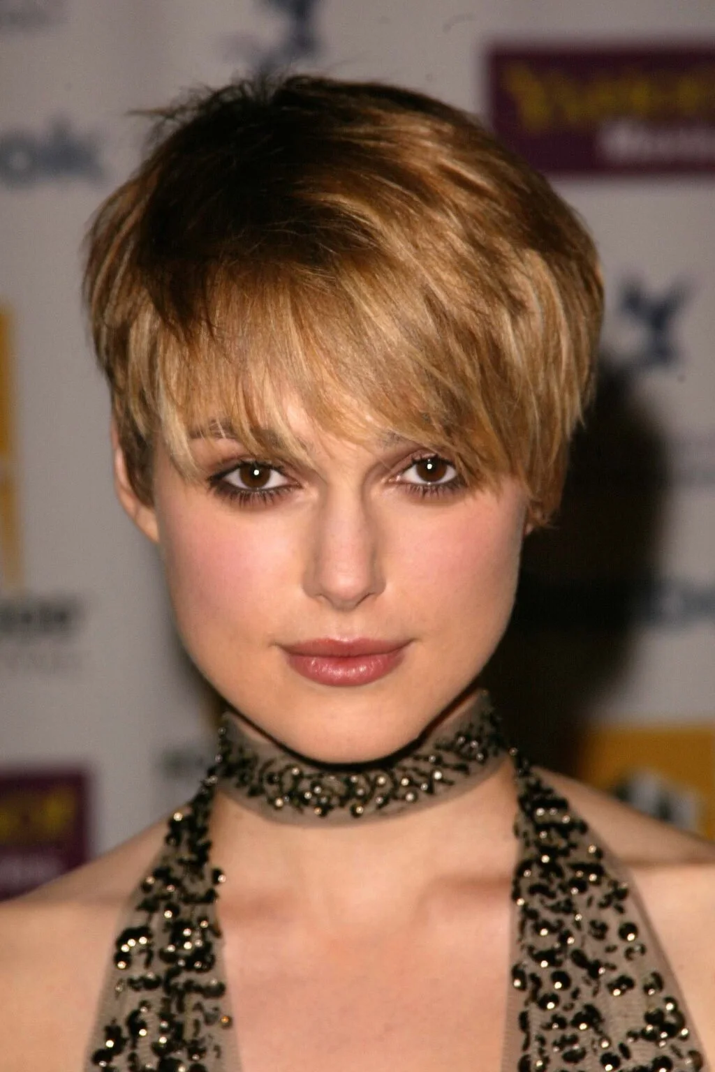 ear straight golden pixie with wispy fringe shown as a thin hairstyles with bangs idea, featuring medium layering, shown in full fringe shaggy pixie