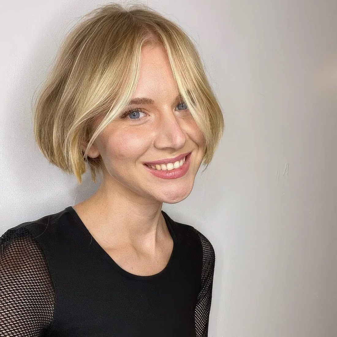 Bright jaw-length blonde bob with highlights and middle part, ask for a razor cut for textured ends.
