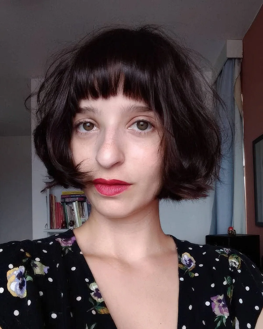 Dark brown chin-length blunt bob with bangs.