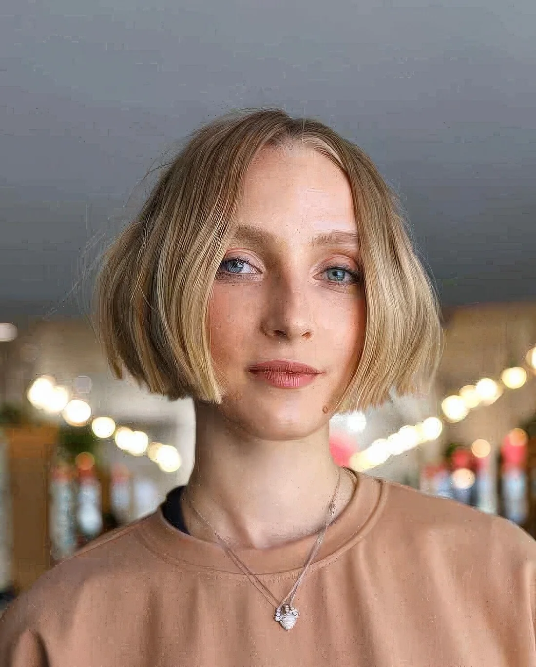 Short blunt blonde bob with a middle part.