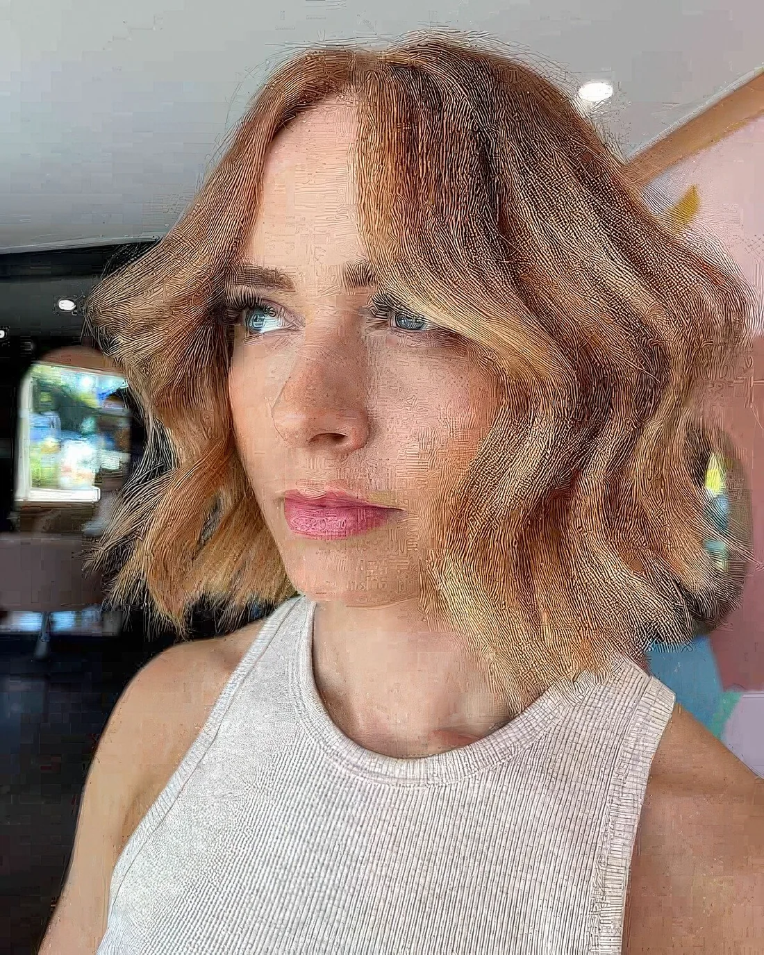 Tousled warm blonde blunt bob, tousled hair.