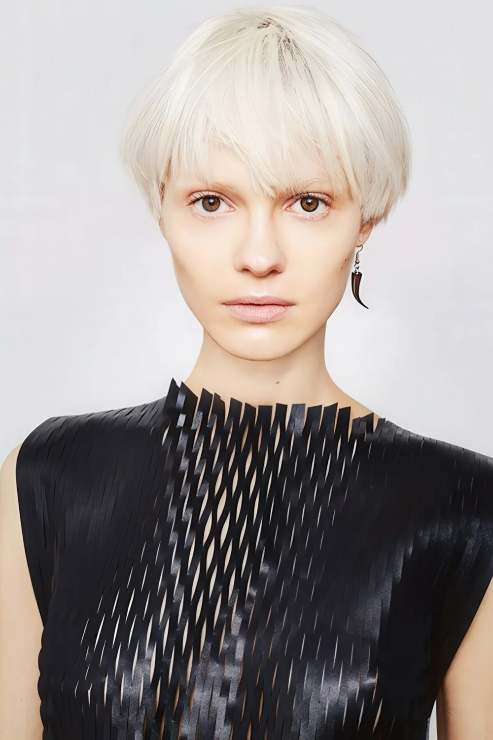 Icy blonde bowl haircut with much texture and enough volume.