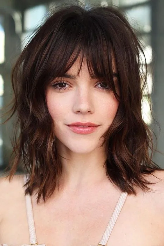 Dark brown shaggy lob with layered bangs.