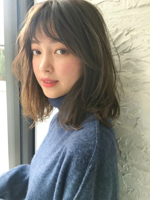 Brown medium-length hair with texture and layered bangs.