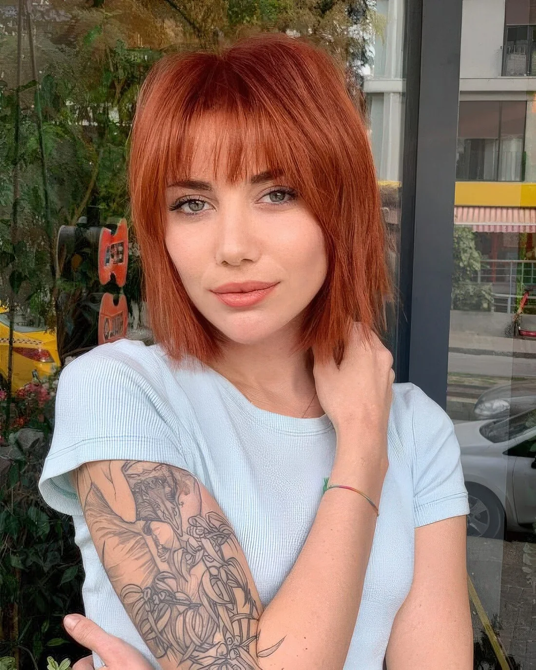 Photo showing wispy and curtain red bob, with the hairstyle clearly visible.