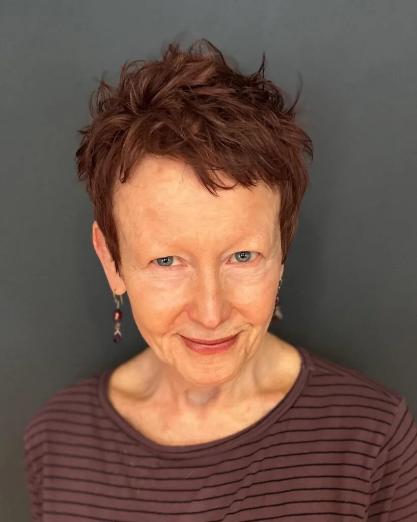 ear straight red pixie with micro fringe shown as a wash and wear haircuts for women over 60 idea