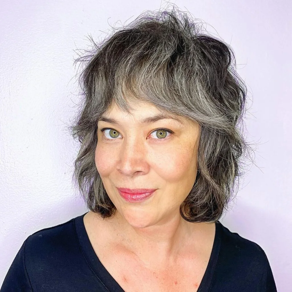 shoulder wavy silver shag with curtain fringe shown as a wash and wear haircuts for women over 60 idea, featuring curtain fringe