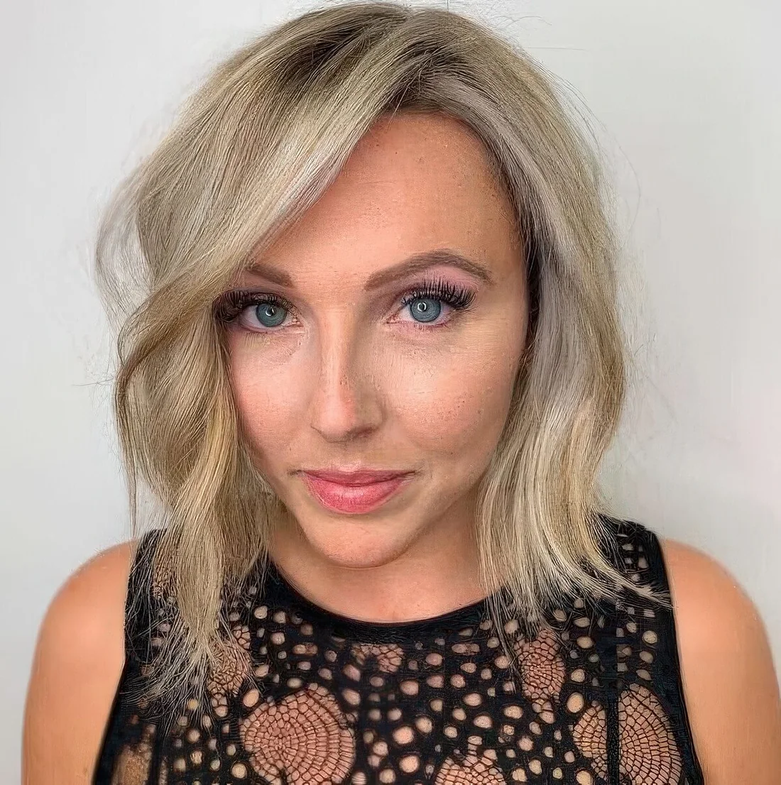 Blonde blunt bob with balayage and side part plus waves that make your hair look thicker.