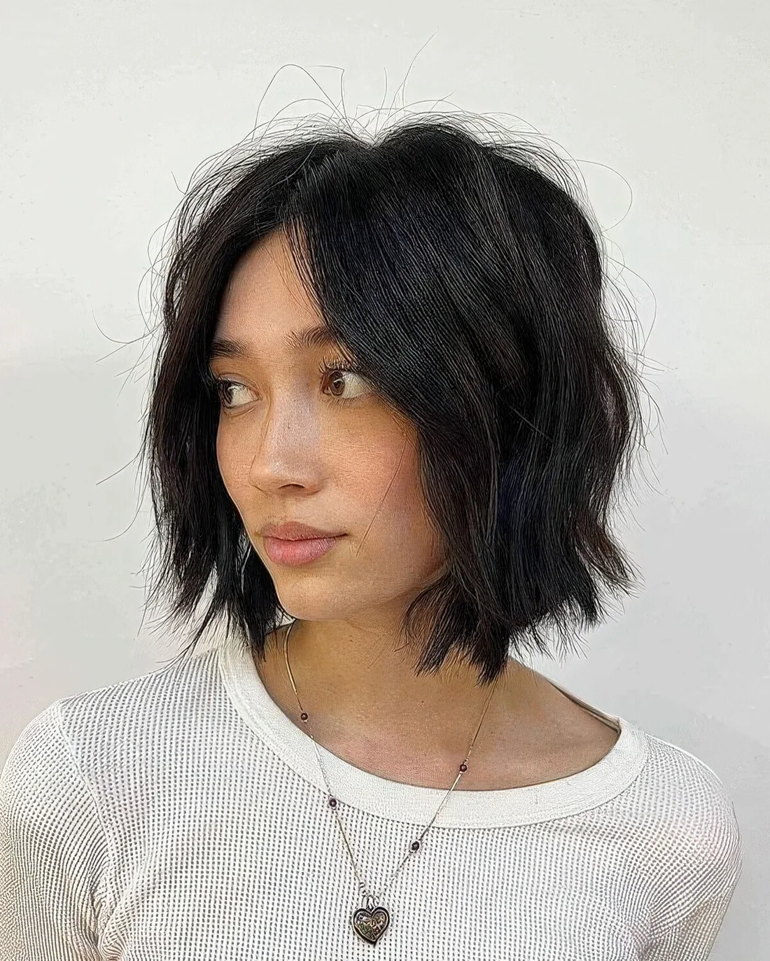 Black choppy bob with center part and waves.