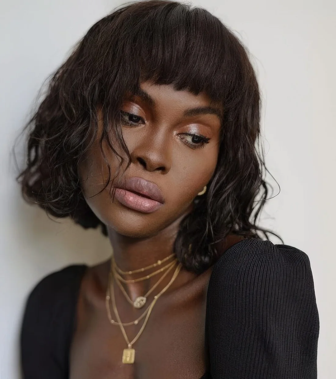 Boy bob haircut done on wavy hair, with a straight top and bangs plus waves down features plenty of texture and.