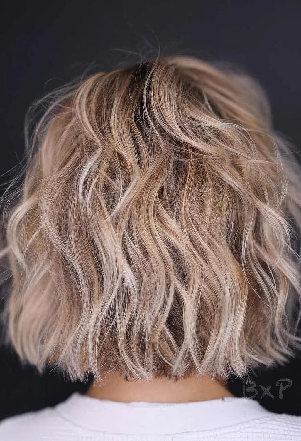Blonde balayage choppy bob with waves.