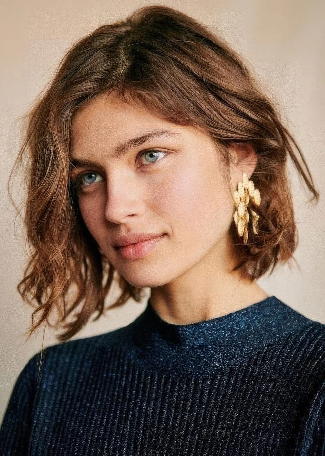 Messy wavy extural brown chin-length bob, with a messy part.