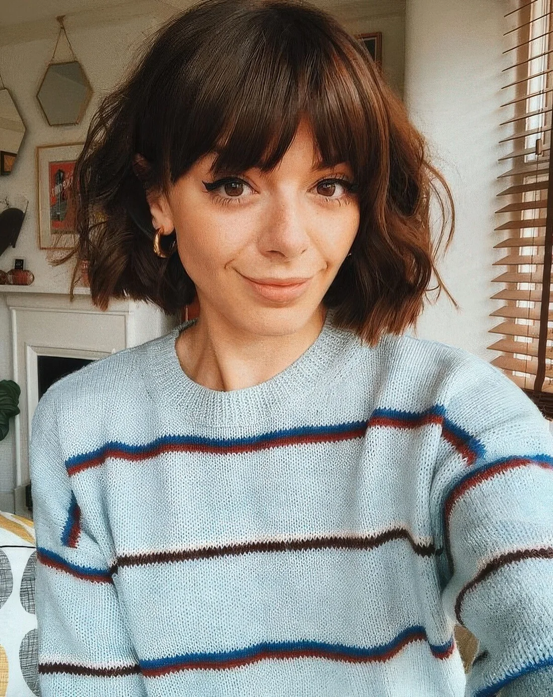 Short brunette bob with waves and bangs.