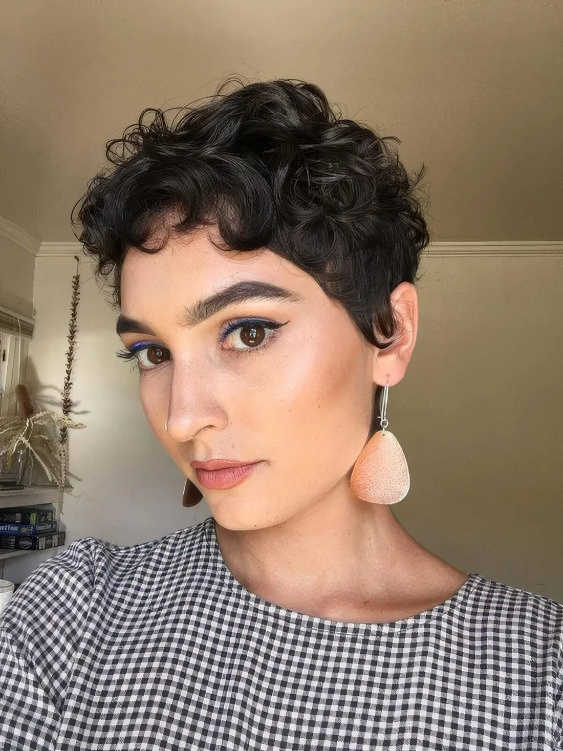 Almost black wavy pixie with a bit of bangs and longer sides.