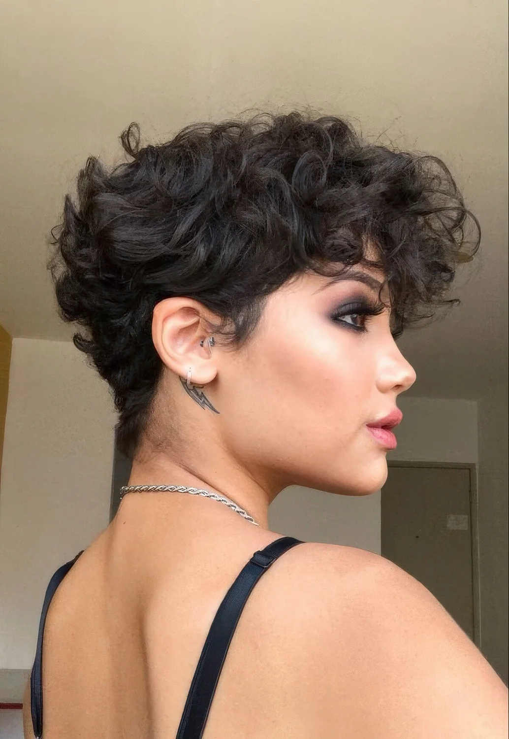 Black wavy pixie with a lot of volume and longer bangs.