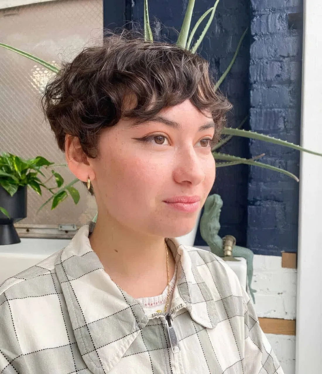 Photo showing brown wavy pixie with bangs, with the hairstyle clearly visible.