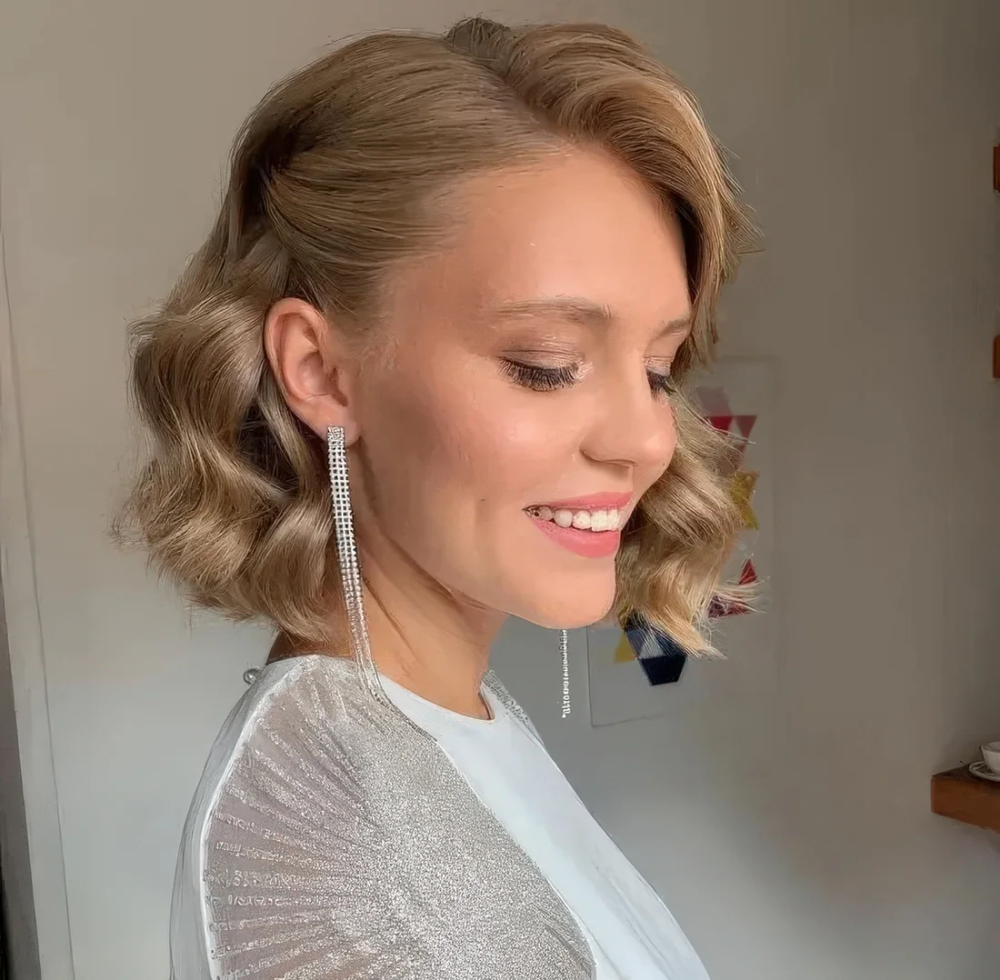 Golden blonde wavy bob with side part, a lot of dimension and some flipped back hair.