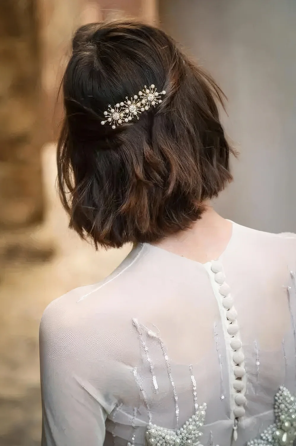 Long bob with wavy hair, styled as a half updo, with a beautiful rhinestone hair barrette.