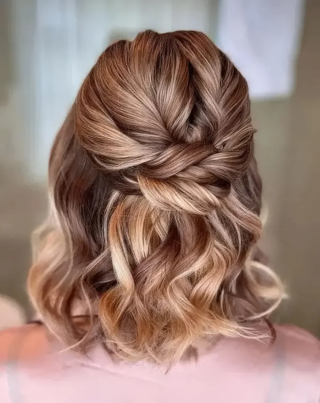 Half updo with a twisted top, a twisted knot and waves down.