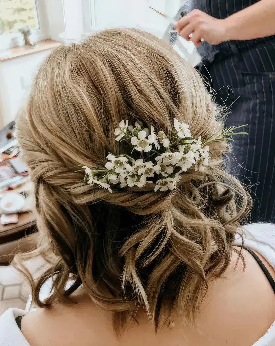 Wavy textured hair with balayage and some fresh blooms tucked in.