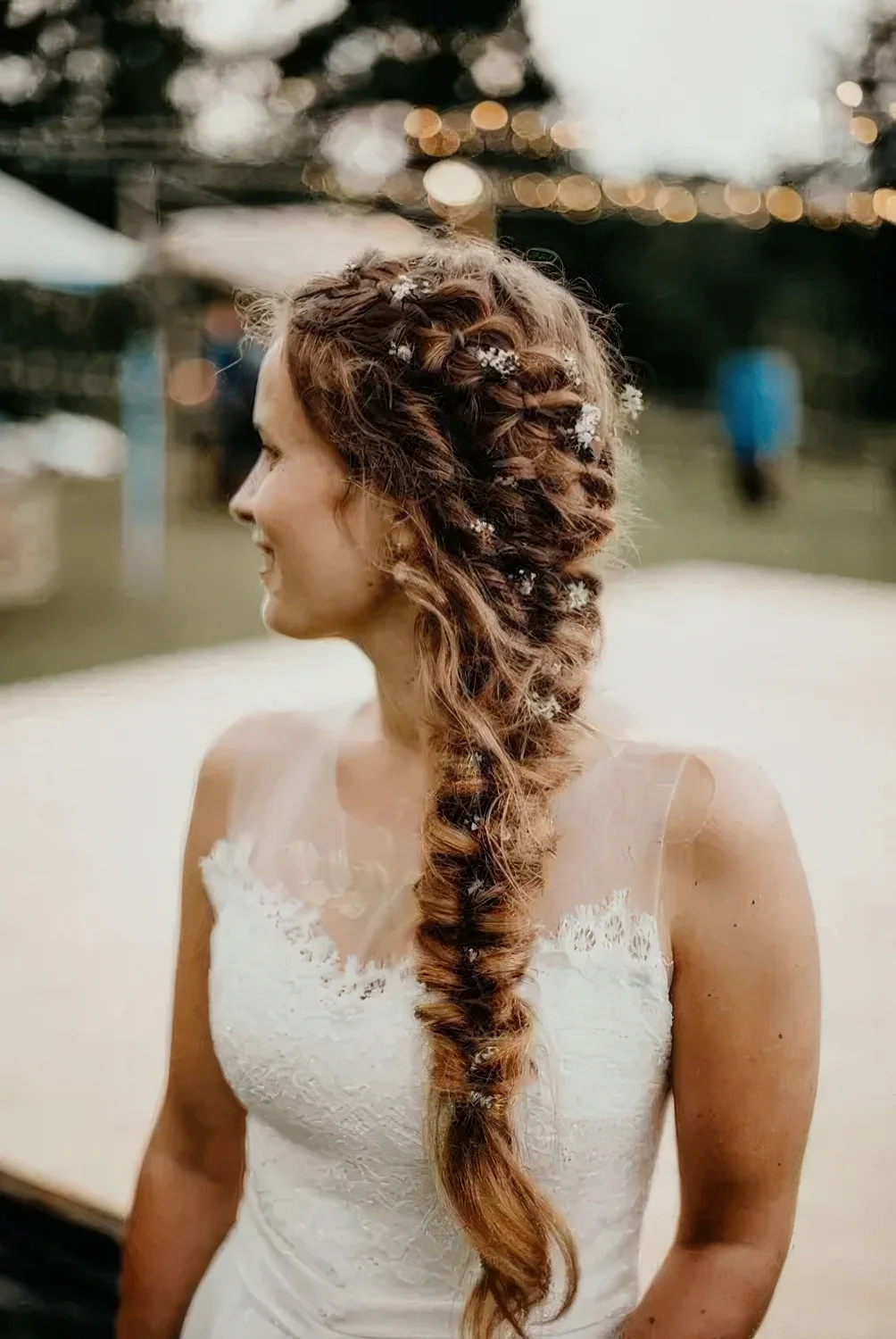 Thick braid composed of several braids and with small blooms tucked into the hairstyle.