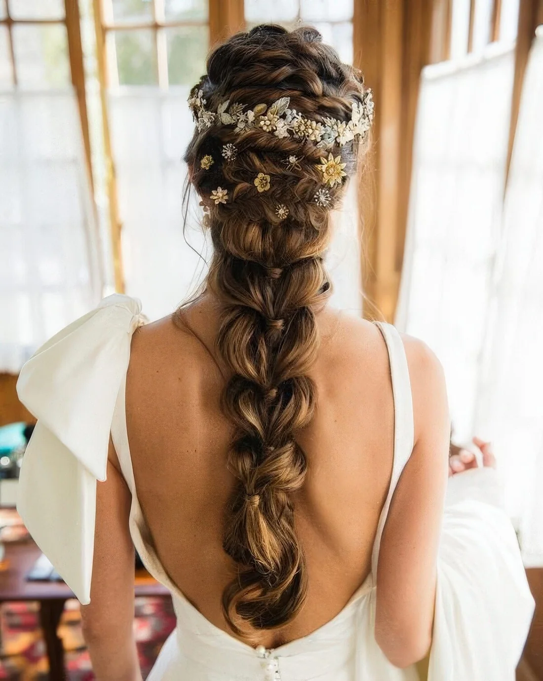 Large loose braid with a braided top and a floral hair vine and hair pins.