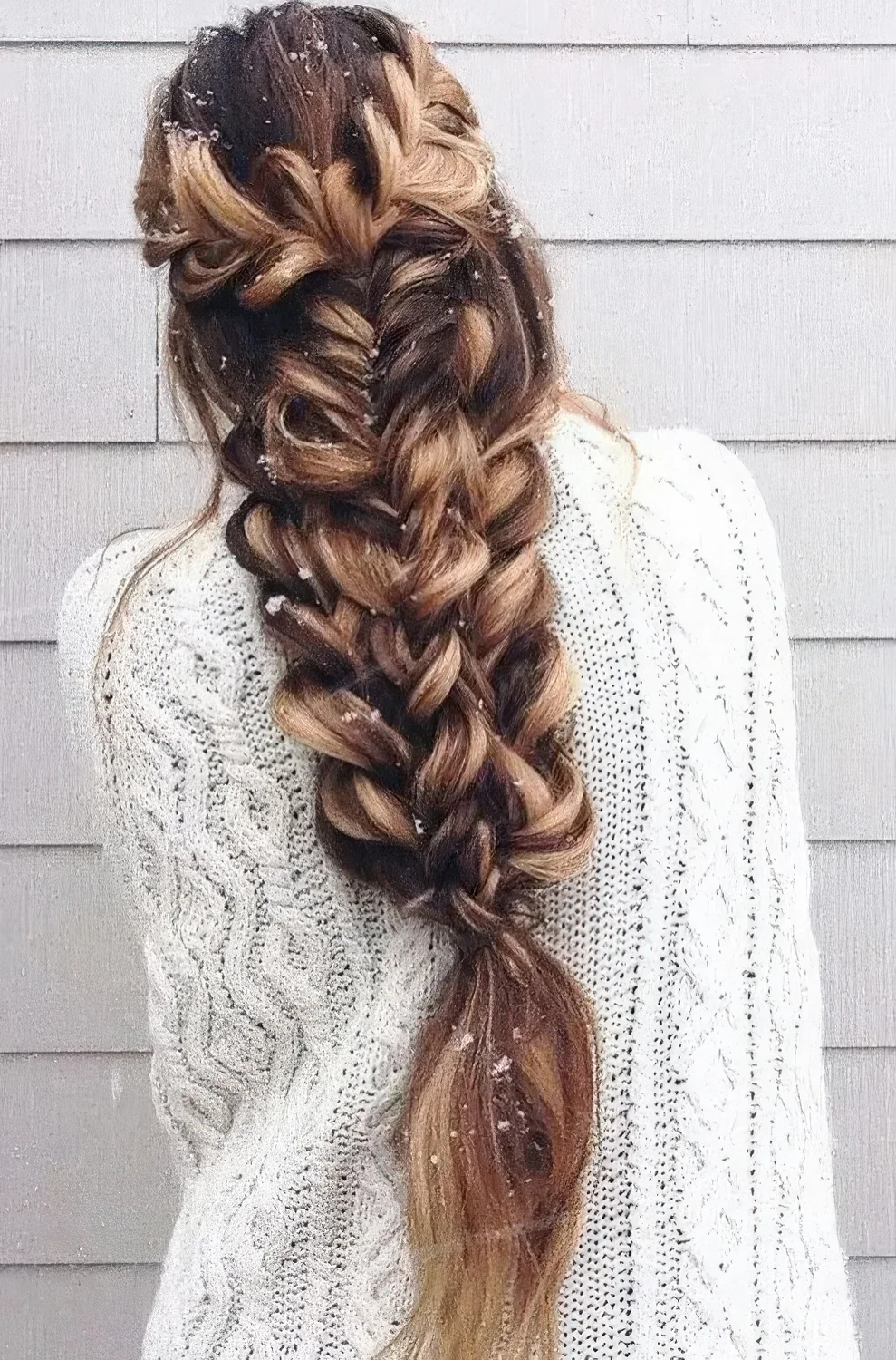 Large voluminous braid made of several braids on long hair.