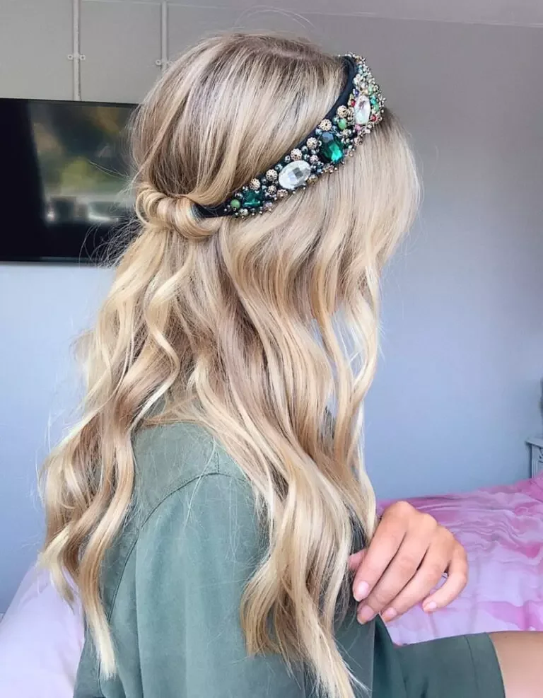 chest curly brunette bun shown as a wedding guest hairstyle idea