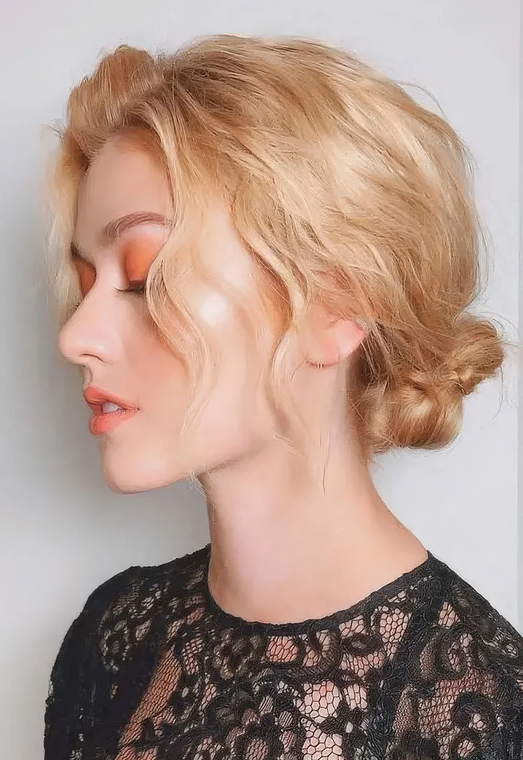 Wavy braided low bun with a wavy top and some face frmaing hair.