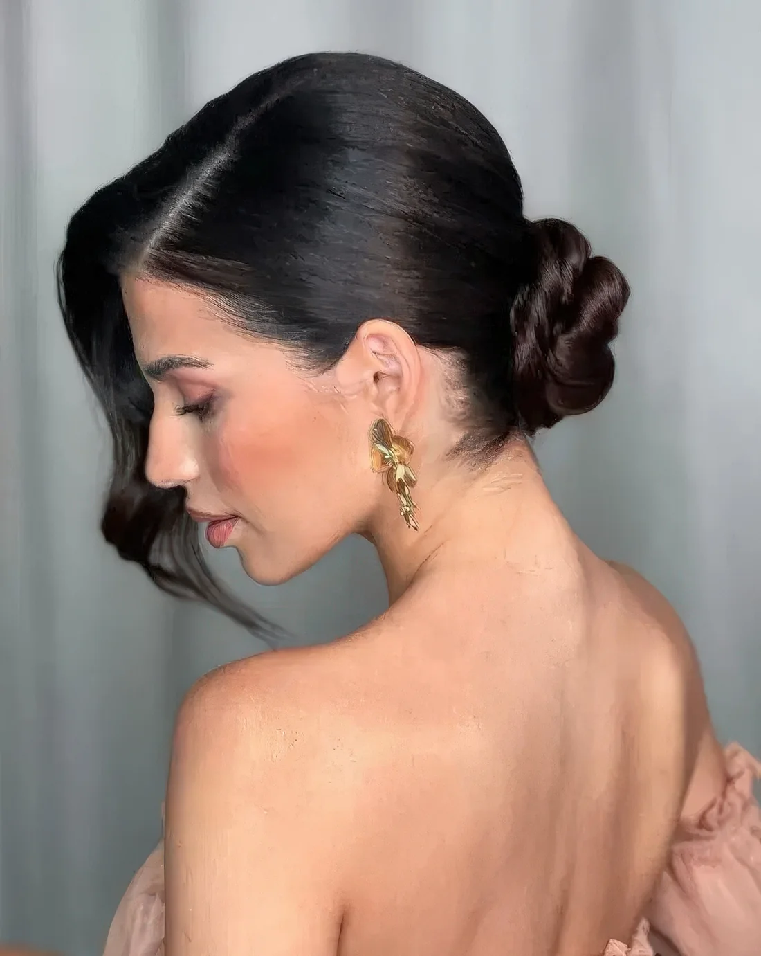 Wrapped low bun, a sleek top and waves framing the face on one side only create a very elegant sophisticated look.