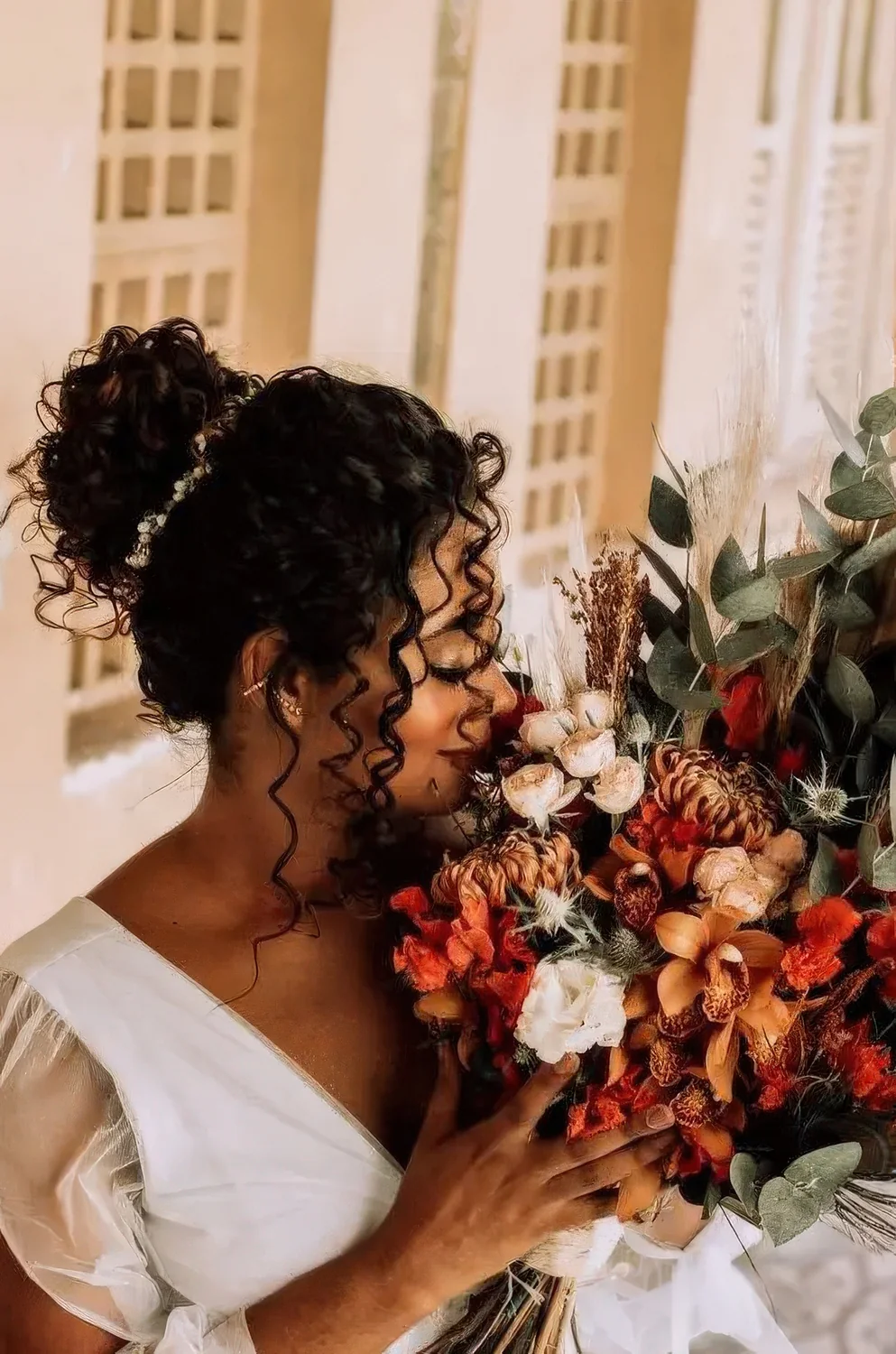 Curly top knot with some curls down and a rhinestone hair vine around the knot.